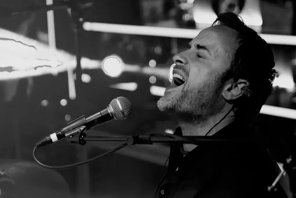 Gianni D’Agostino singt am Mikrofon, schwarz-weiss