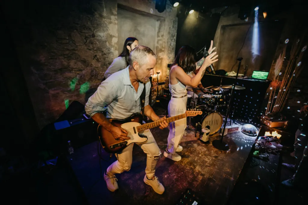 Gitarrist und Sängerin von MAXiN bei einer Party