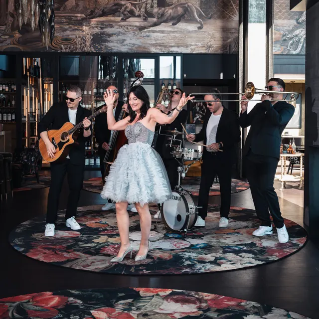 Band MAXiN mit Sängerin im Tüllkleid auf rundem Teppich
