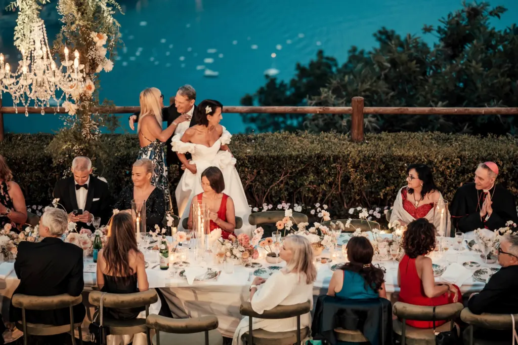 Brautpaar und Gäste an der Tafel über dem Meer, Hochzeit in Ravello, Italien