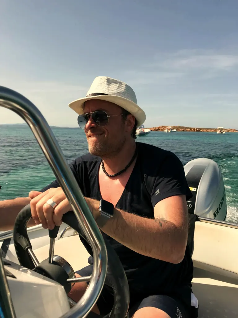 Musiker von MAXiN am Steuer eines Boots vor der Küste bei Olbia, Sardinien, Italien