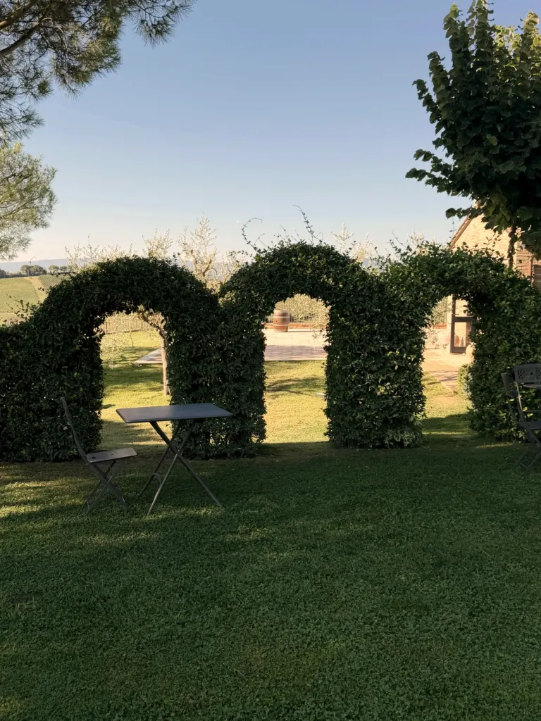 Archi di siepi nel giardino del Borgo Tre Rose, Toscana, Italia